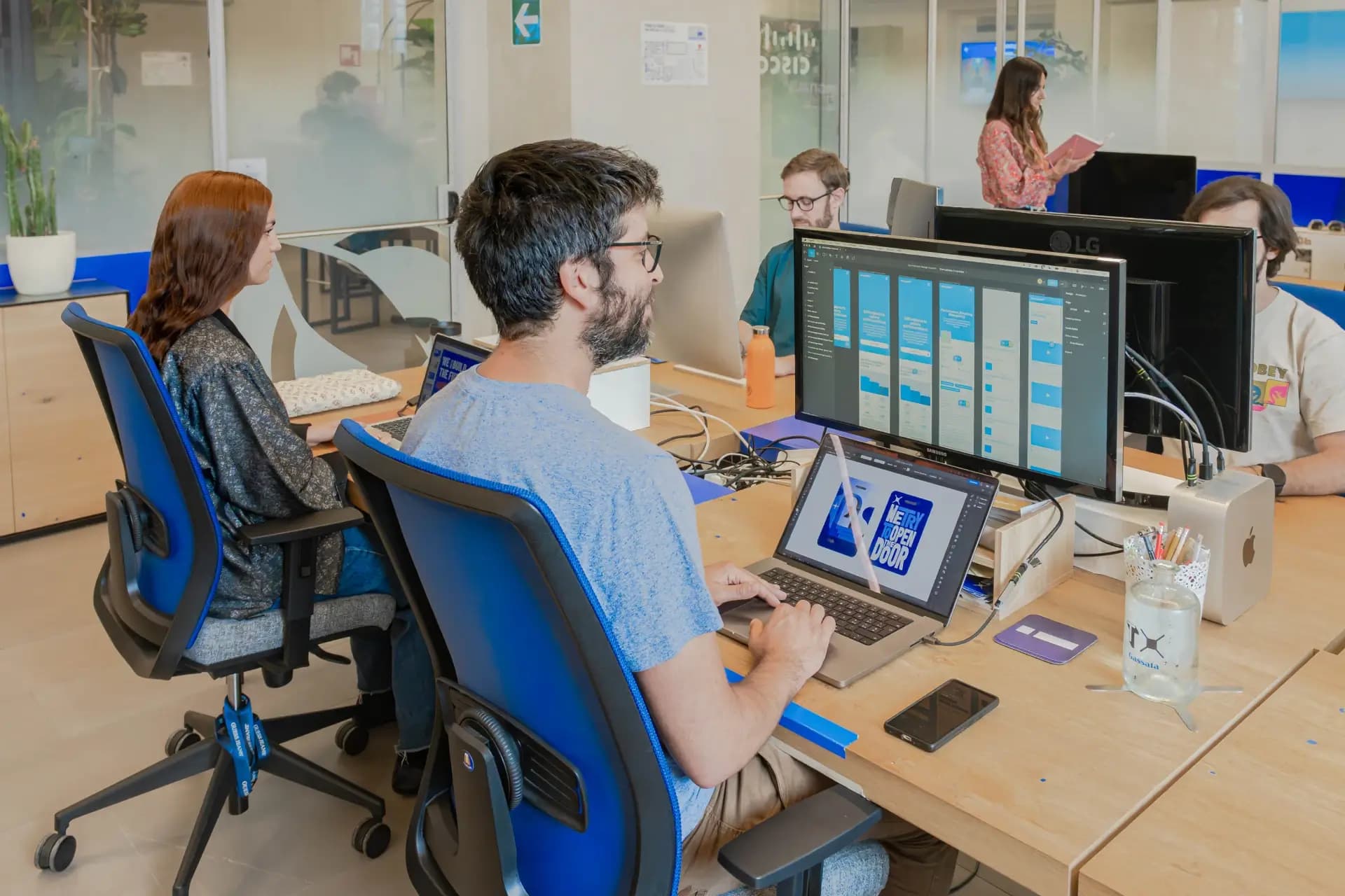 Spazio di coworking a Nana Bianca, Firenze, con postazioni di lavoro moderne e professionisti al lavoro in un ambiente dinamico e collaborativo.