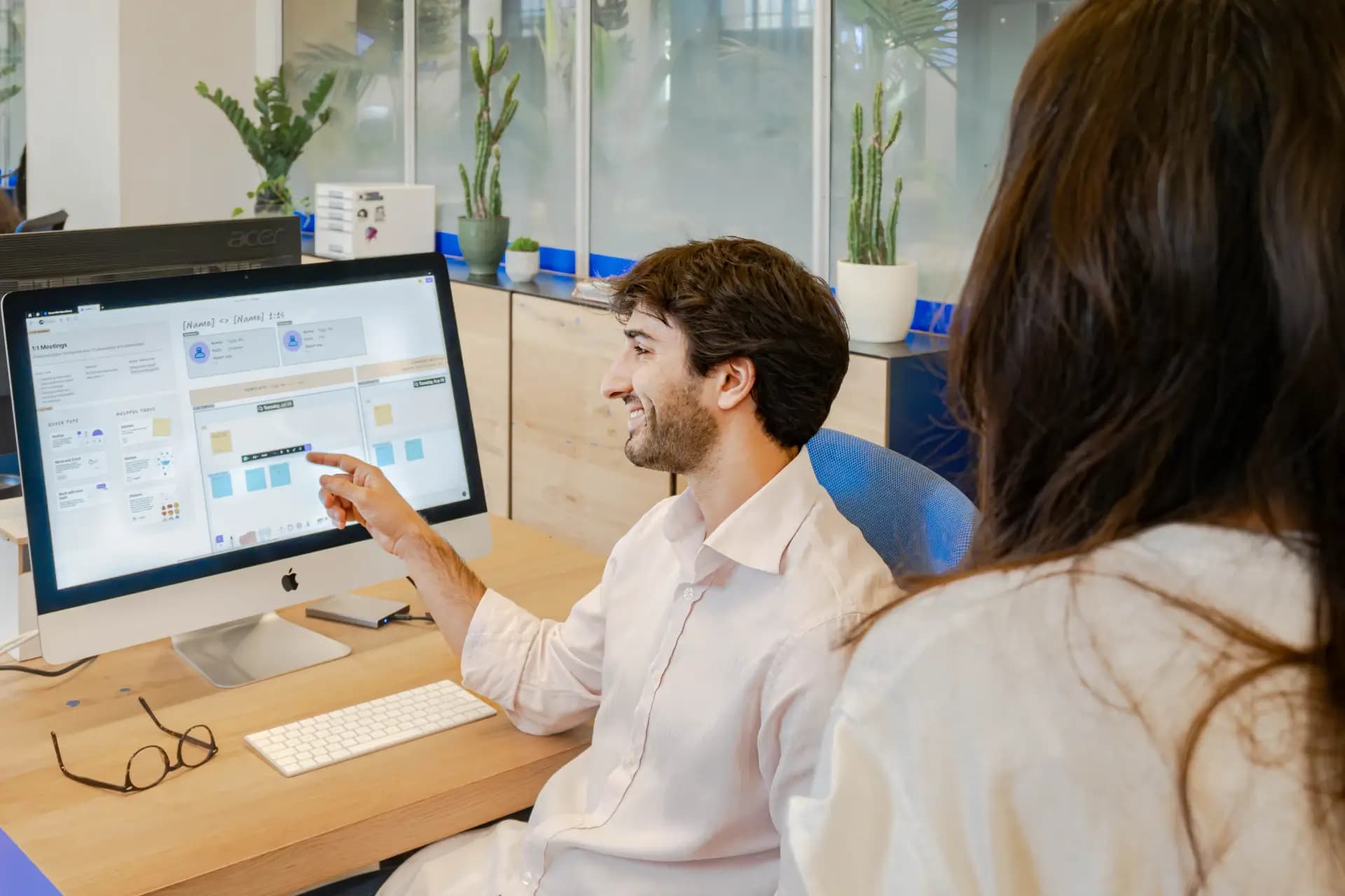 Scrivania attrezzata con monitor multipli in uno spazio di coworking a Nana Bianca, ideale per startup e aziende digitali a Firenze.
