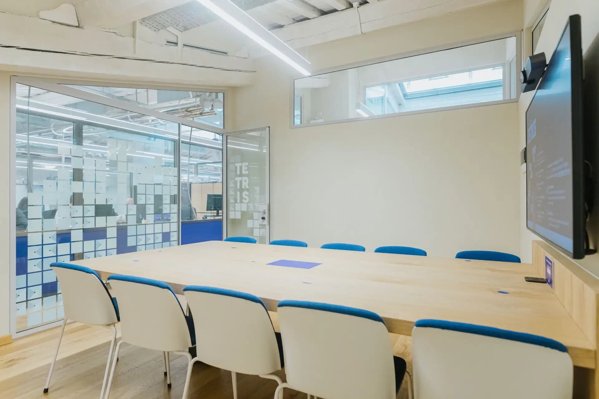 Sala riunioni Tetris a Nana Bianca, Firenze. Spazio di lavoro collaborativo con tavolo ampio, sedute ergonomiche e schermo interattivo per conferenze e workshop. Ideale per aziende e coworking.