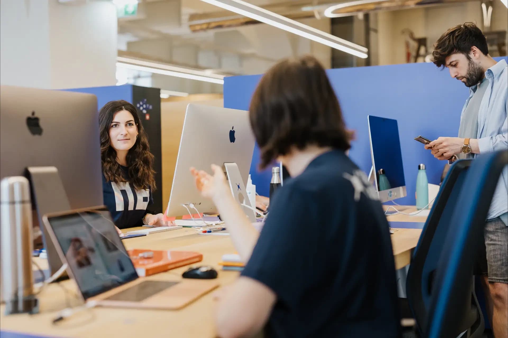 Open space di Nana Bianca a Firenze, con professionisti al lavoro su postazioni moderne e dotate di iMac. Un ambiente dinamico perfetto per startup, freelance e team innovativi.