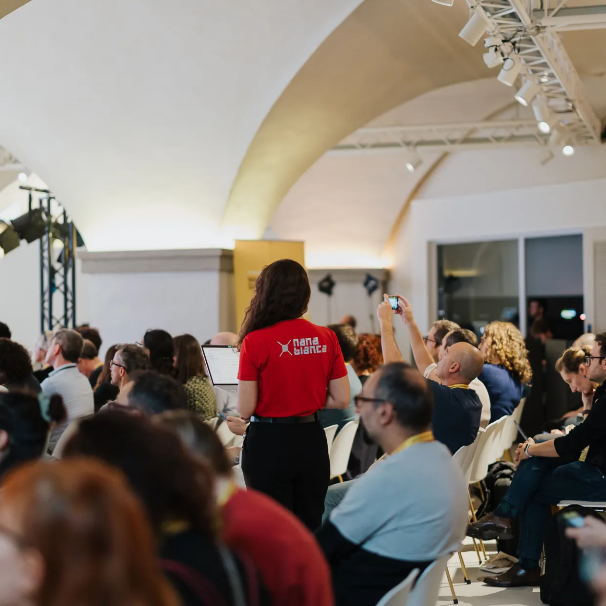 Ragazza che presenta un pitch su un palco durante un evento di startup, presso la sede dell'Innovation Center di Nana Bianca e FCRF a Firenze. L'evento è parte del programma di accelerazione Hubble, Cybershield, CTE Prisma, Italian Lifestyle, Bravo Innovation Hub ed Estra e-qube.